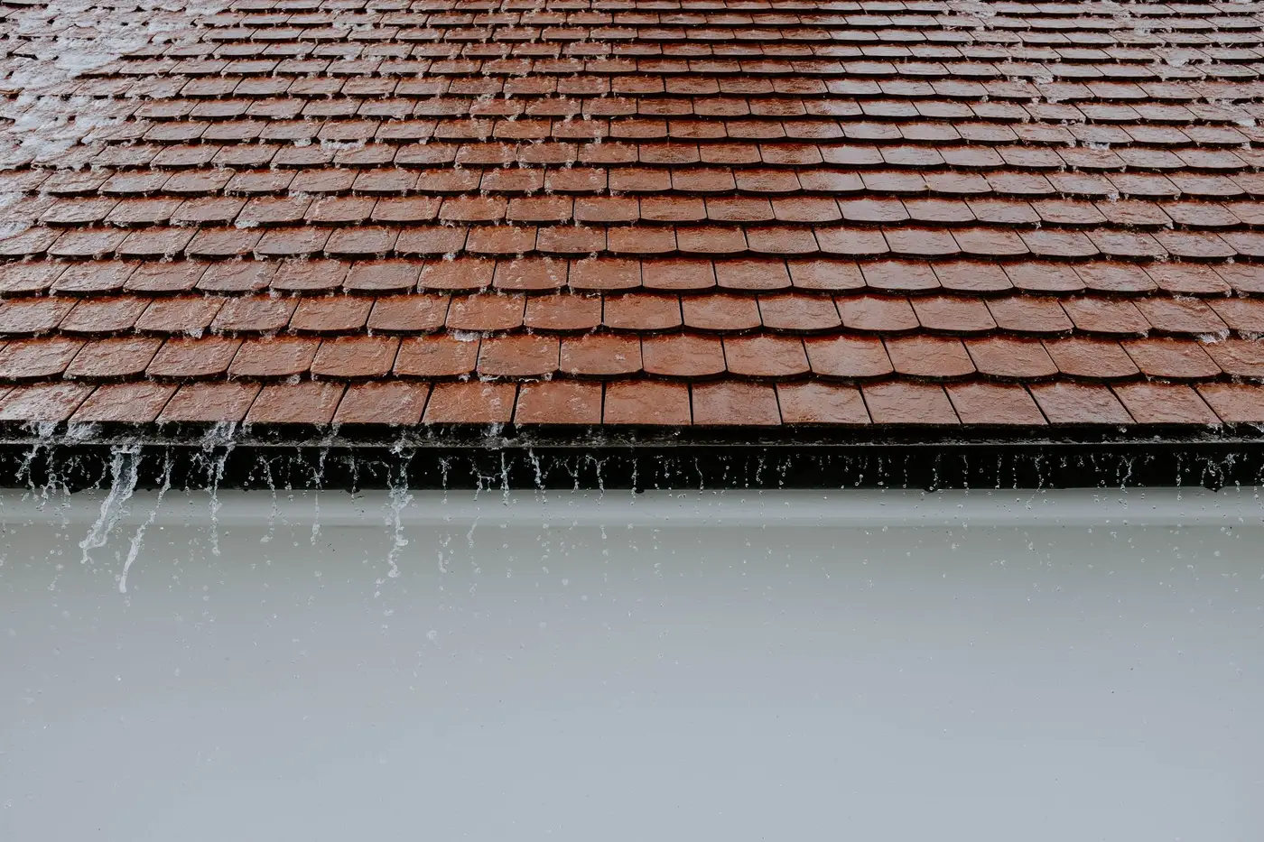 Rain running off a tiled roof edge